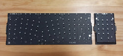 Top-down view of X-Bows Knight Plus ergonomic mechanical keyboard printed circuit board assembly (PCBA) and detachable numpad module on a wooden surface.